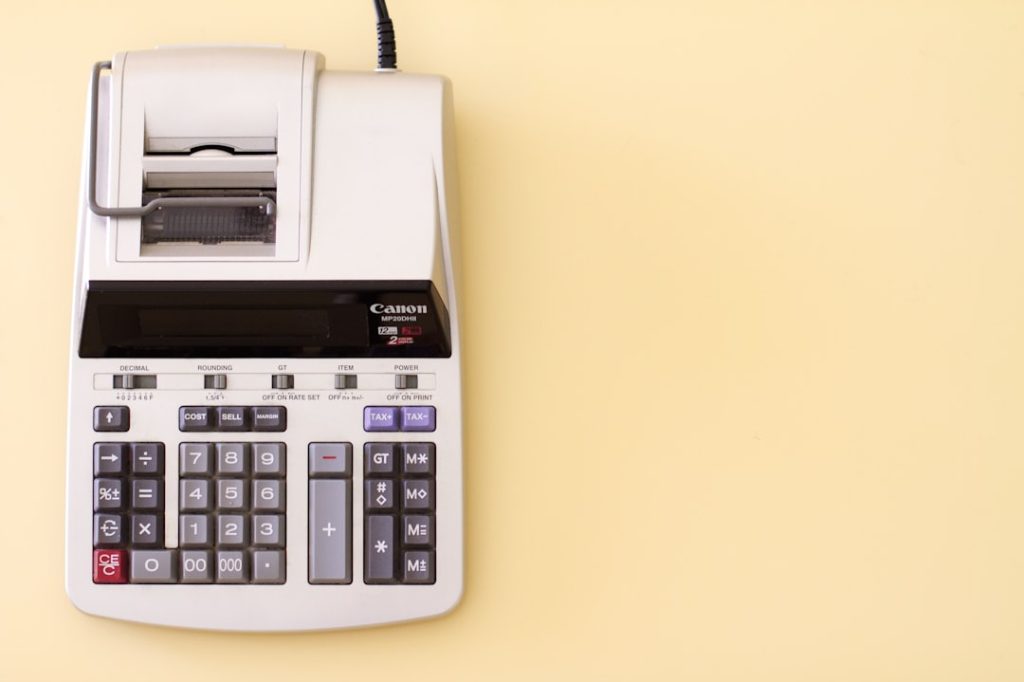 Ten key accounting calculator on yellow desk.